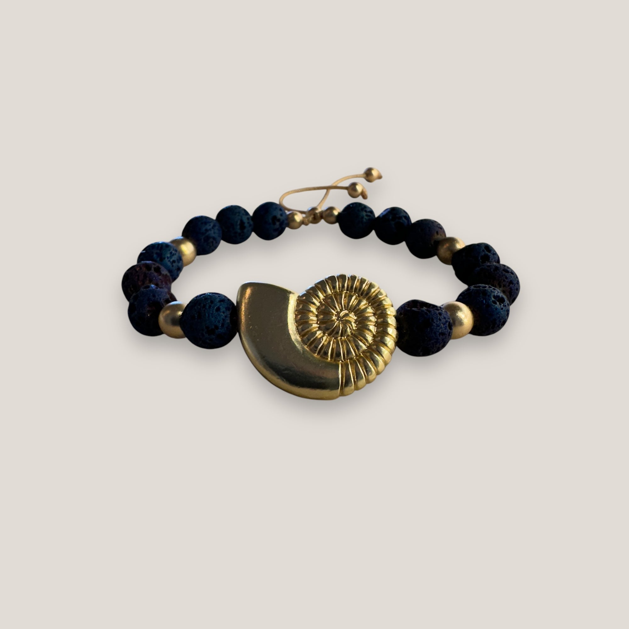 Armband mit großer Muschel und goldenen Perlen mit indigoblauer Lava