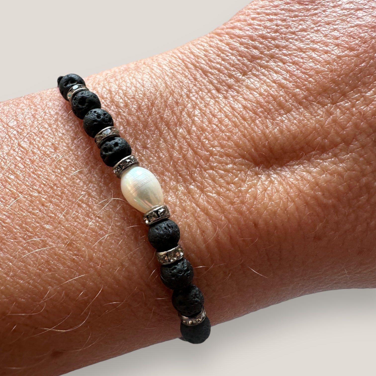Pulsera midi perla blanca con 8 cuentas de lava negra y brillis gunmetal con cristalitos blancos