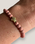 Pulsera con tortuguita dorada y lava rosa