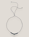 Collar midi con moneda tribal dorada, cuentas de lava negra y separadores oro y brillis negros