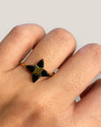 Goldener Ring mit vierzackigem Stern und schwarzem Onyxstein aus Stahl und Gold.
