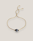 Minimalistisches Armband mit einer 8 mm großen hellblauen Schwammkorallenkugel und goldenen Trennelementen mit funkelnden weißen Kristallen.