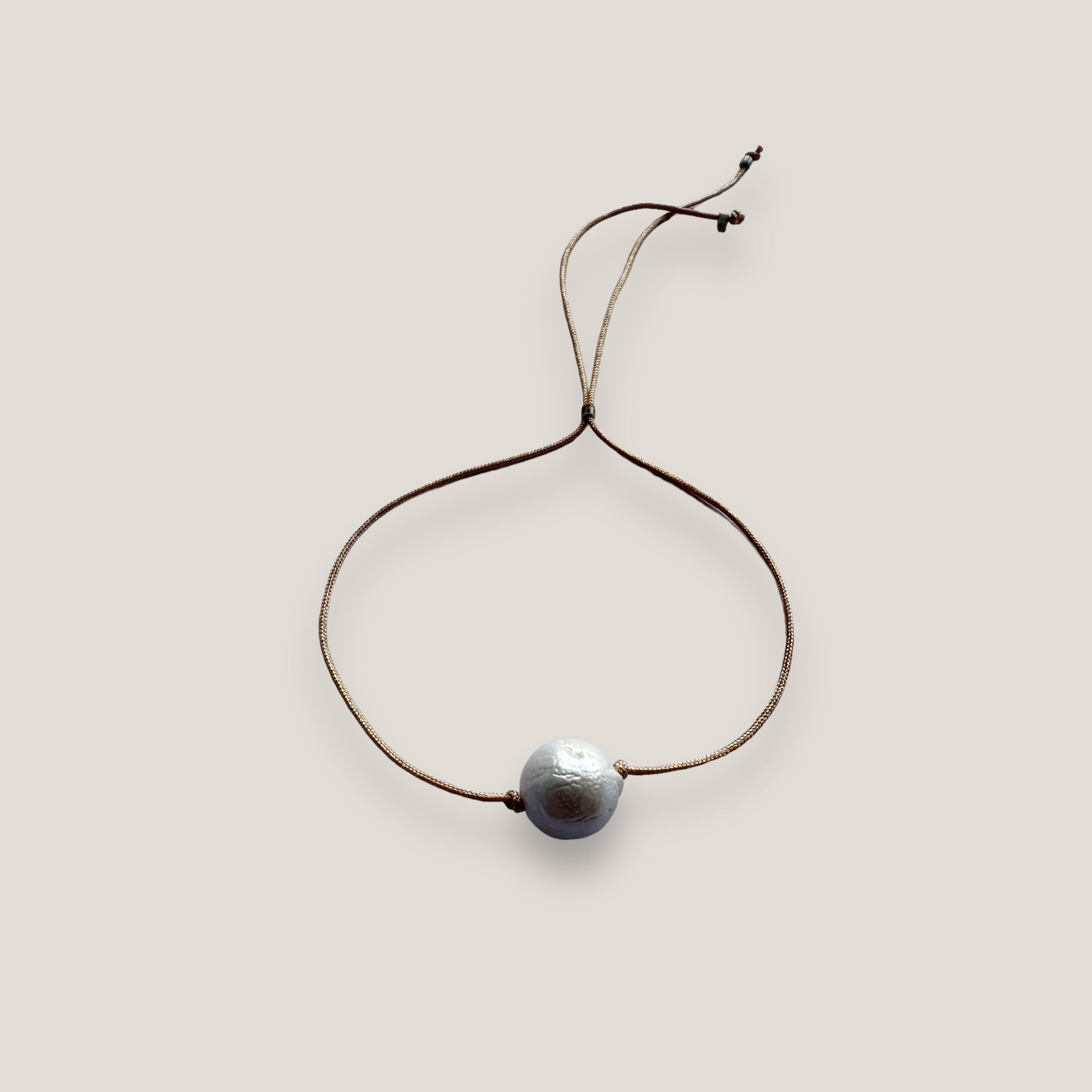Pulsera minimal con gran perla natural blanca y cordón de nailon