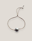 Pulsera minimal con gran perla natural blanca y cordón de nailon