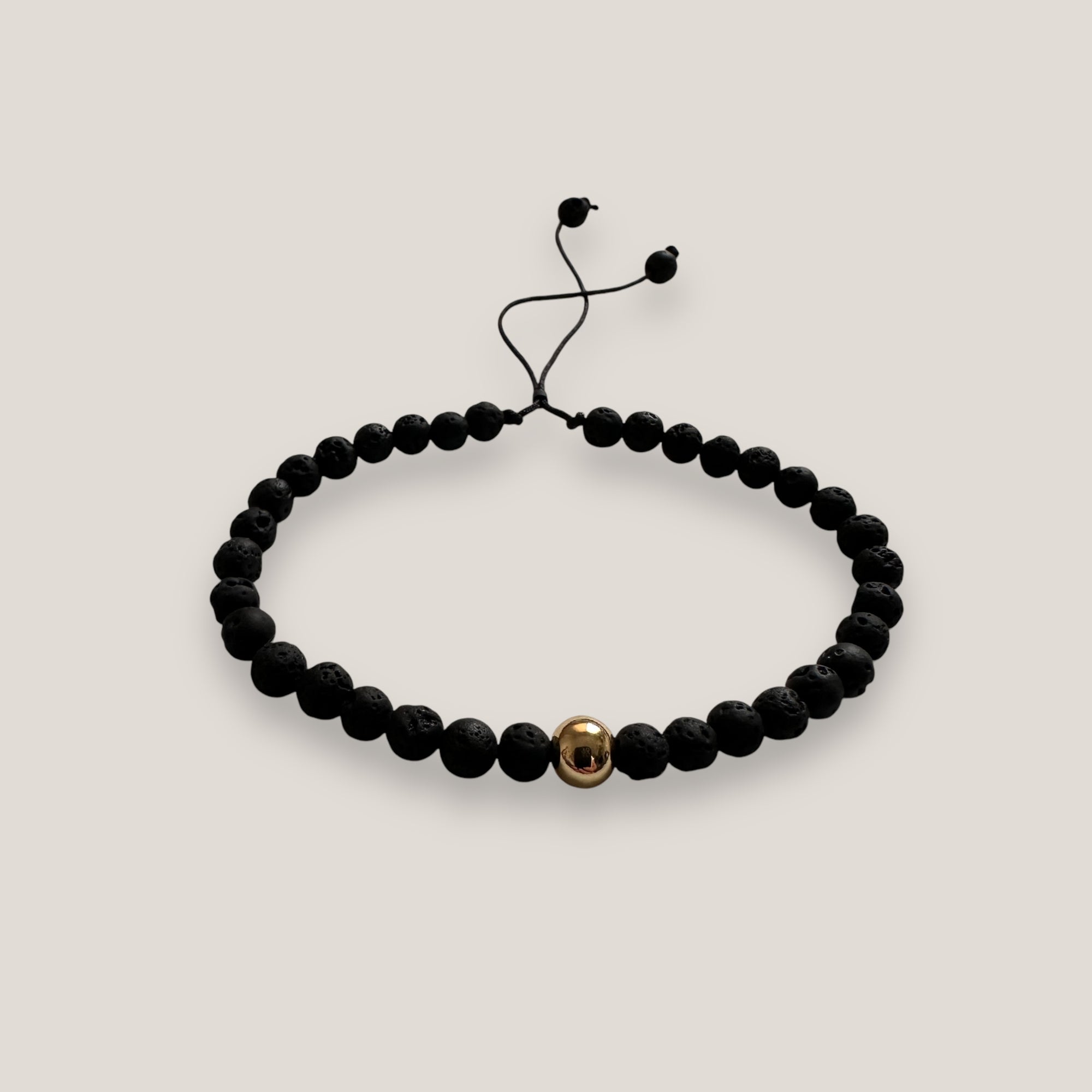 Armband mit goldener Stahlkugel und schwarzer Lava