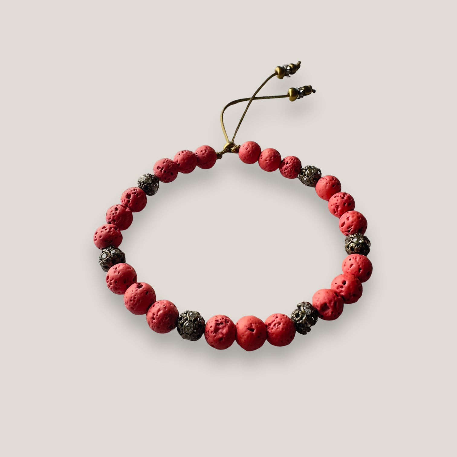 Pulsera Dafne con lava rojo coral y filigrana bronce con cristalitos