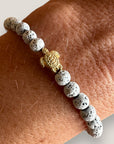Pulsera con tortuguita dorada y lava blanca