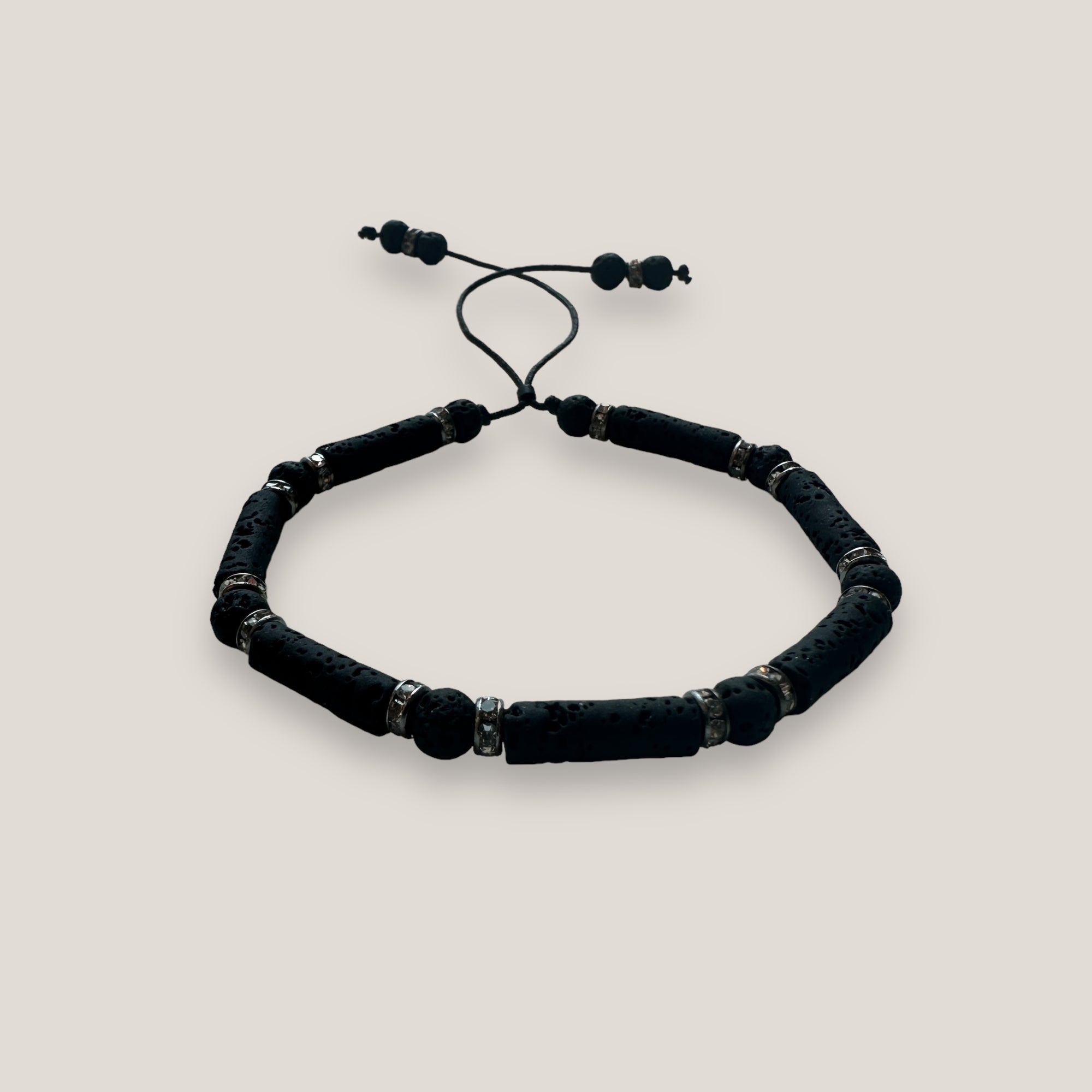 Pulsera con tubos y cuentas de lava negra y brillis gunmetal con cristalitos blancos