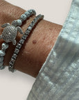 Pulsera con tortuga brillis plateada con lava blanca y más brillis