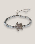 Pulsera con tortuga brillis plateada con lava blanca y más brillis