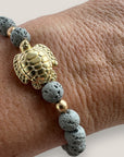 Pulsera con gran tortuga dorada y lava gris claro