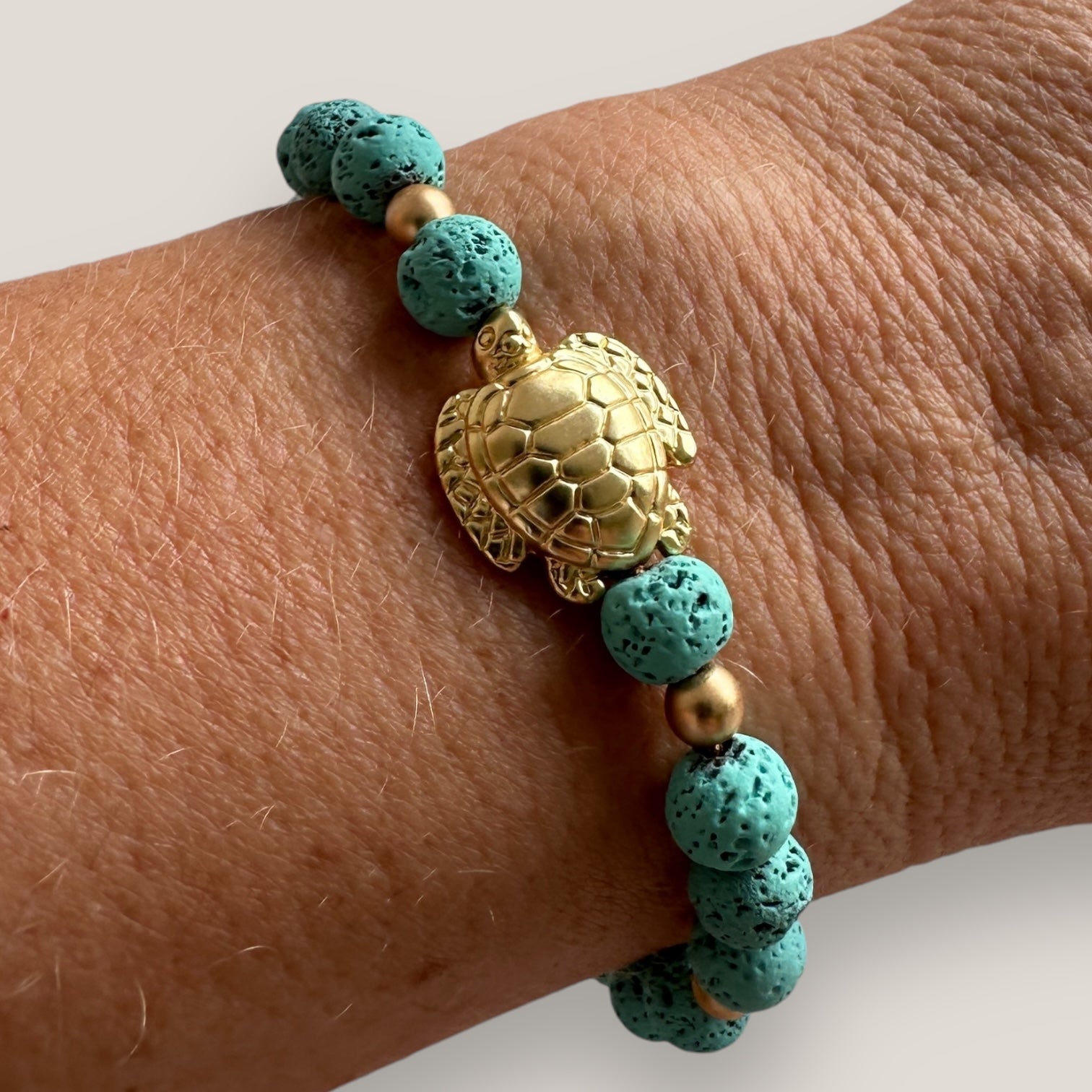 Armband mit großer goldener Schildkröte und türkisblauer Lava