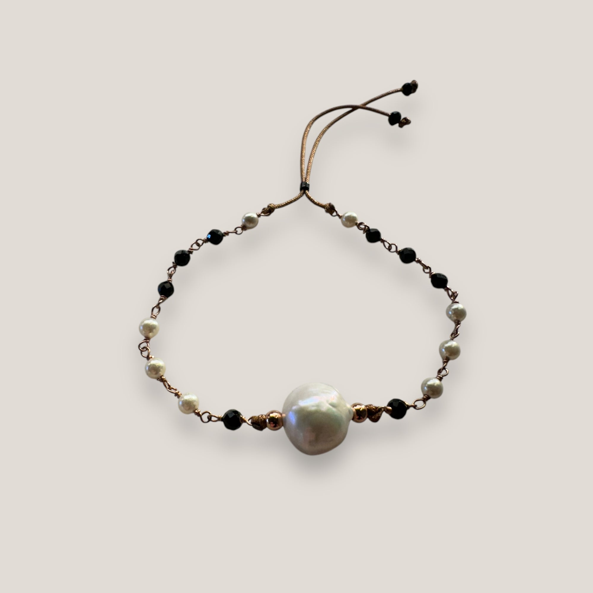 Conjunto Divino negro con perla natural blanca, cristales facetados negros y perlitas blancas naturales, engarces en oro rosa