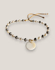 Pulsera con cristales facetados gris electrochapado y perlitas engarzados con medallita de nacar