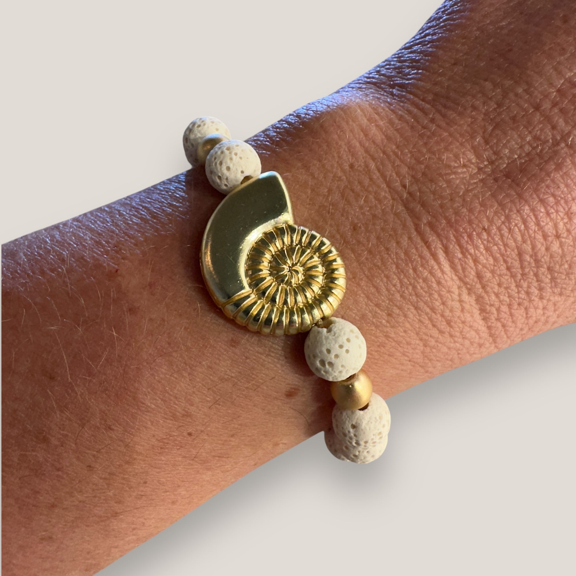 Pulsera con gran caracola y cuentas doradas con esponja coral blanca