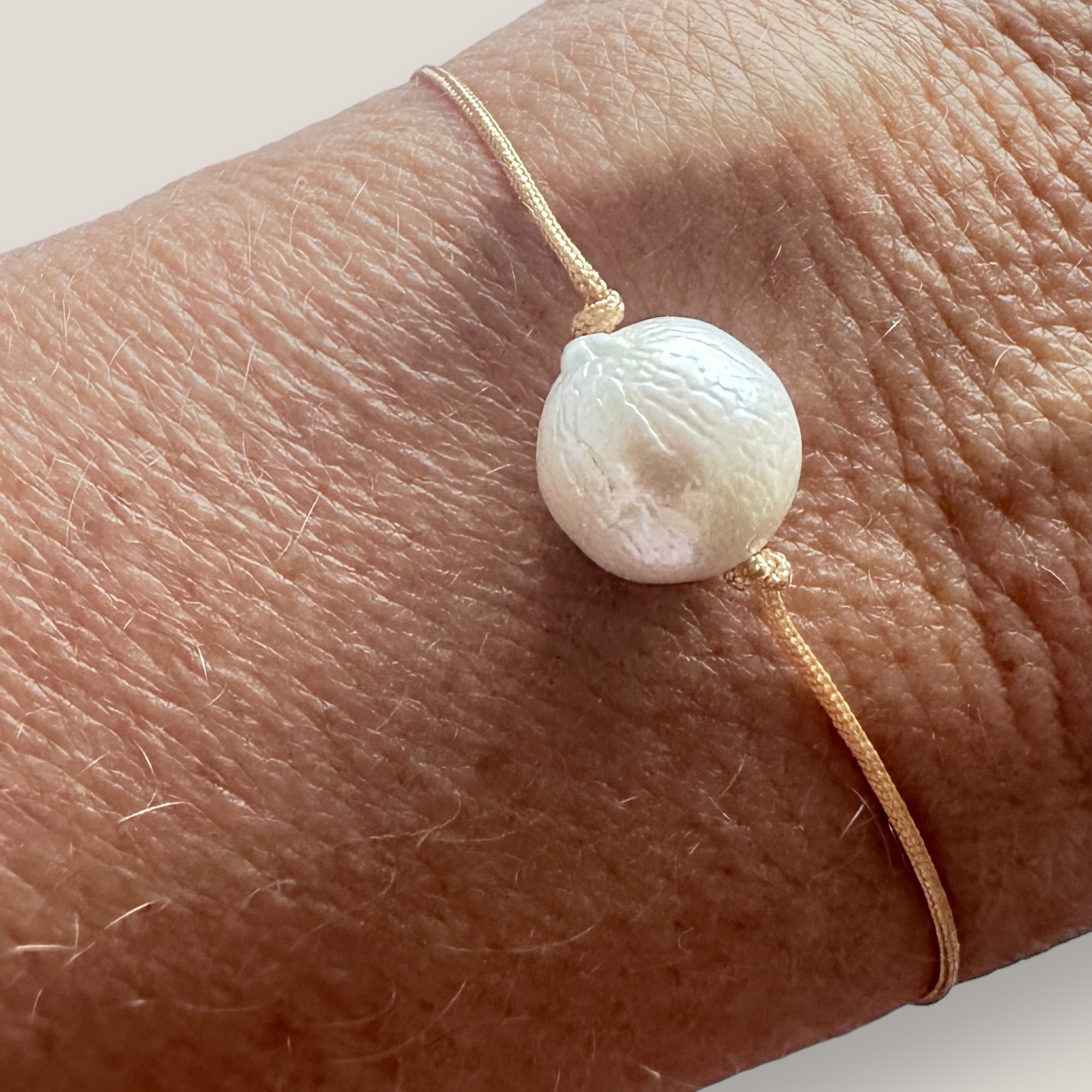 Pulsera minimal con gran perla natural blanca y cordón de nailon