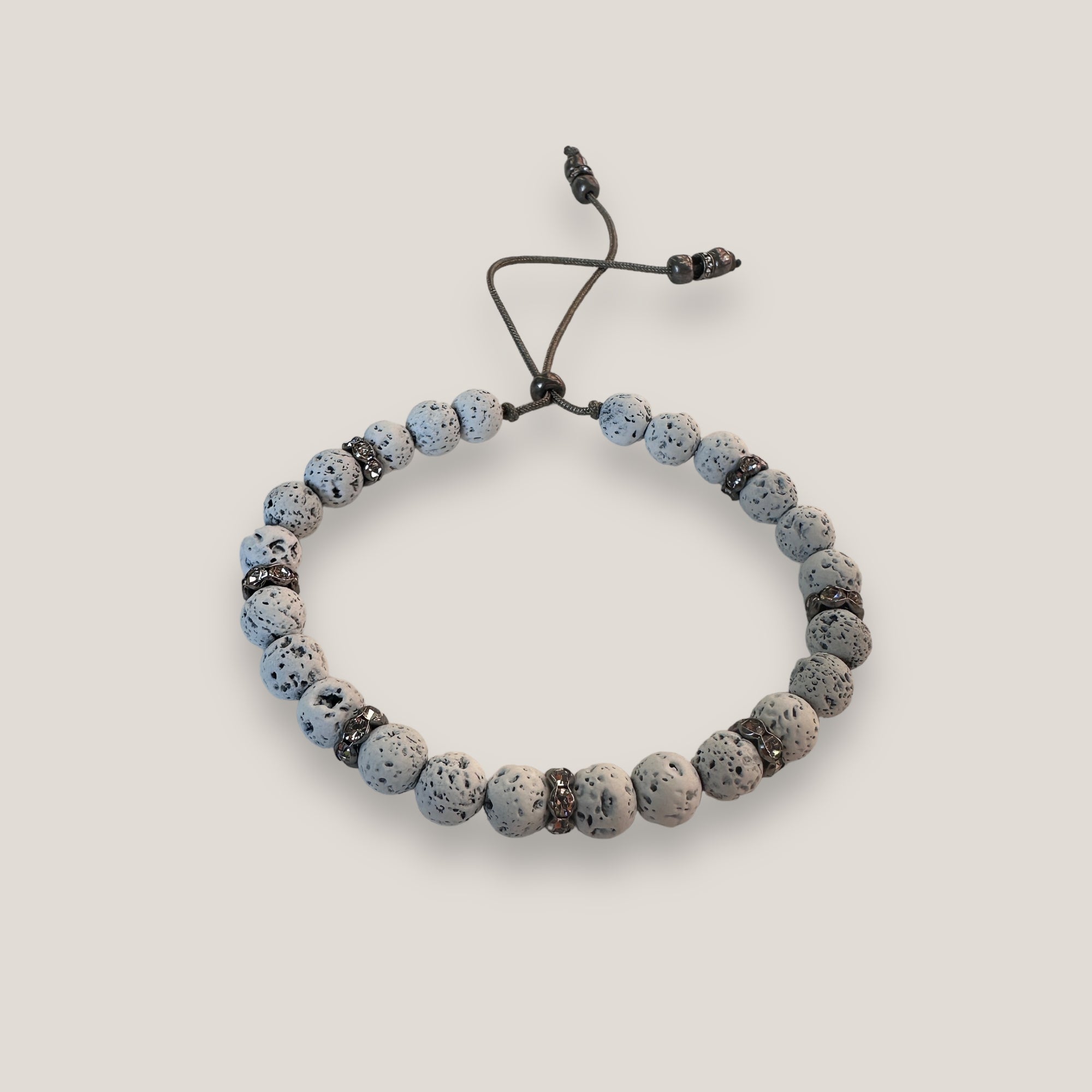 Pulsera Lilith con cuentas 6mm de lava blanca y brillis gunmetal con cristalitos blancos