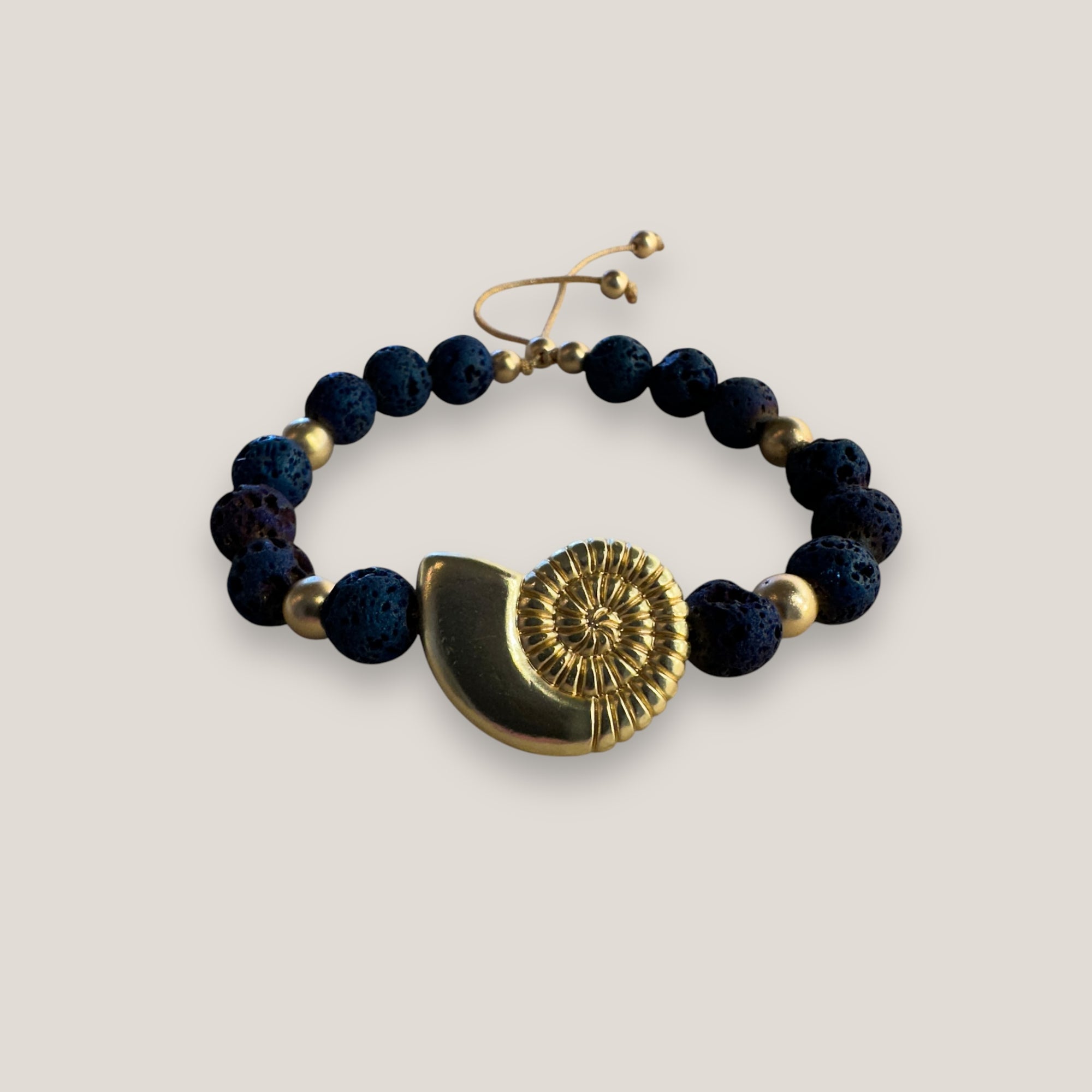 Armband mit großer Muschel und goldenen Perlen mit indigoblauer Lava