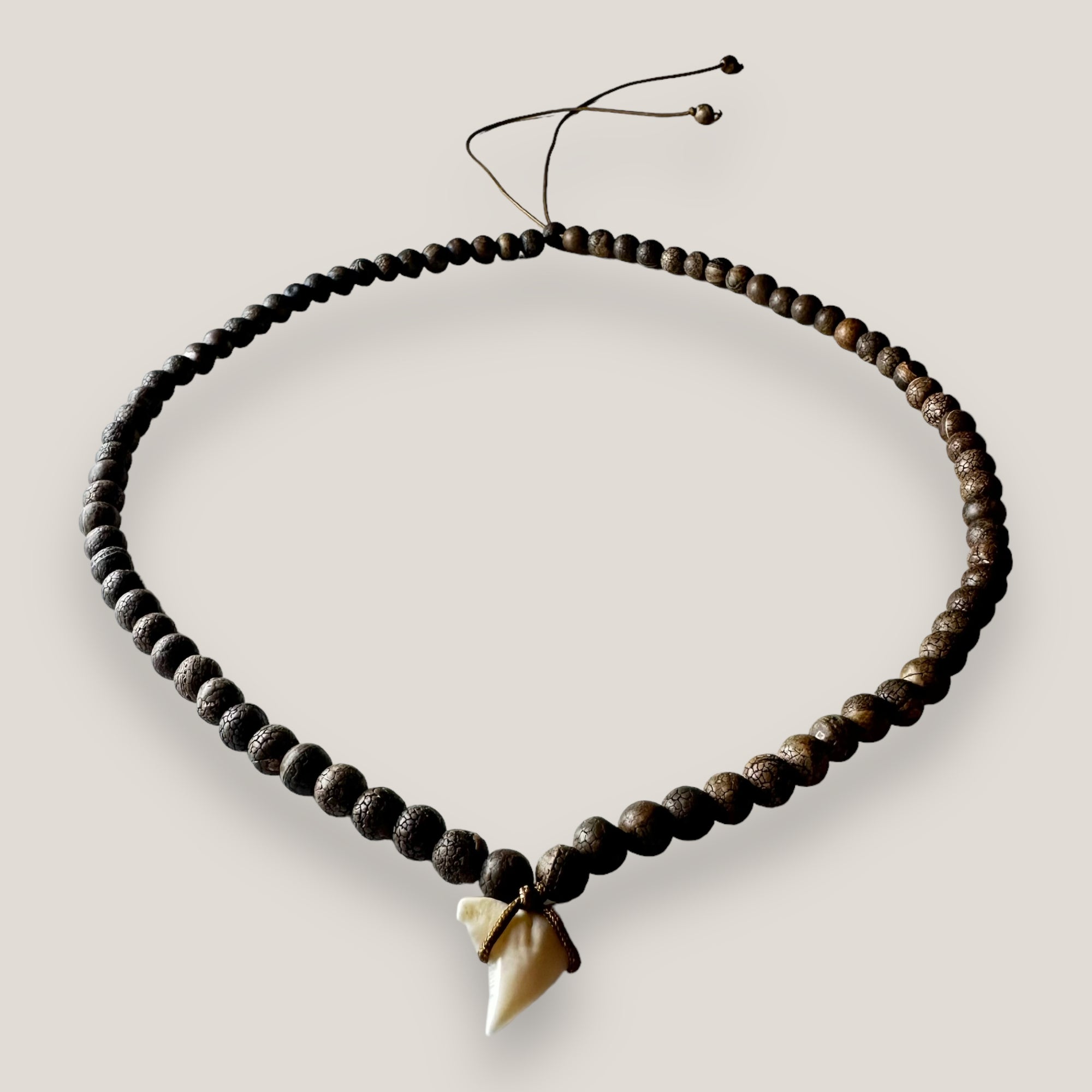 Collar con diente de tiburón y cuentas de piedra marrón oscuro