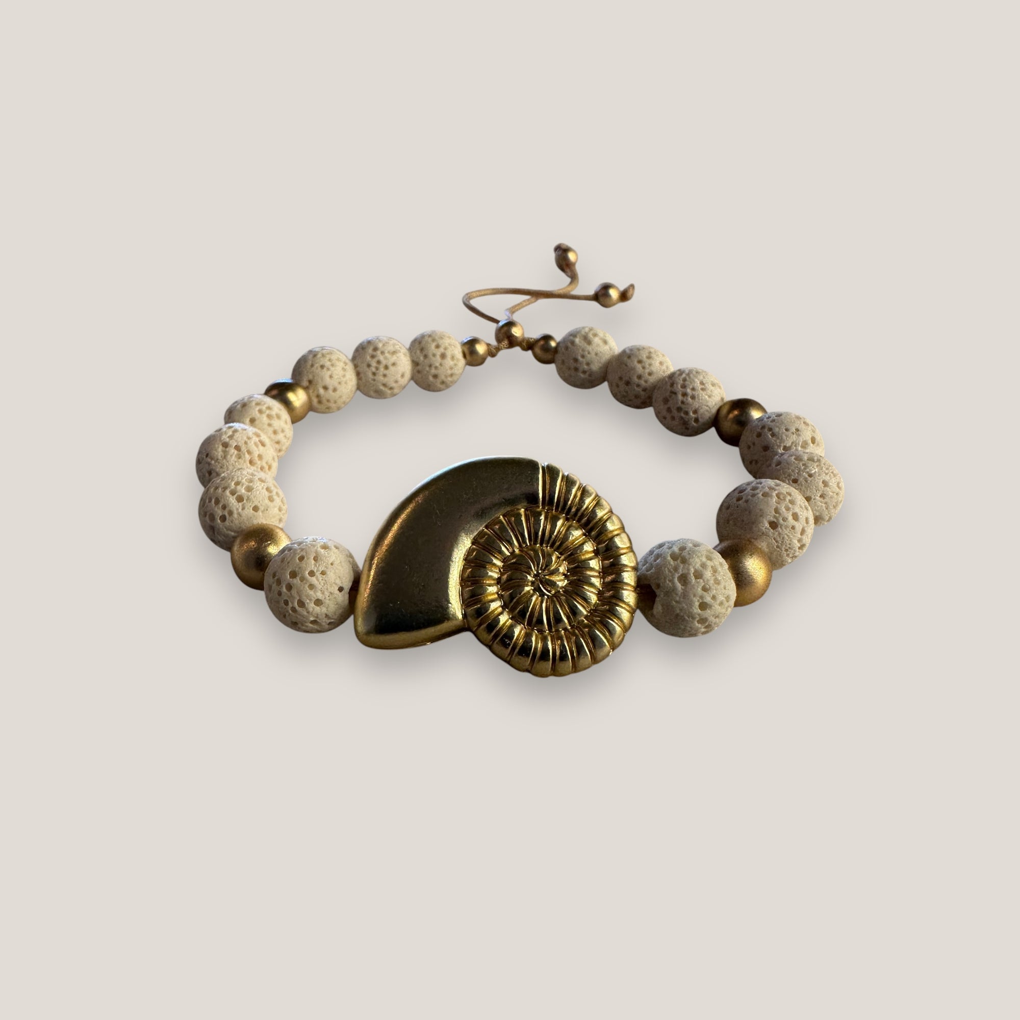 Pulsera con gran caracola y cuentas doradas con esponja coral blanca