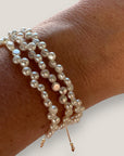 Pulsera triple con perlitas 4mm blancas naturales, cordón de nailon color dorado y cuentas acero oro