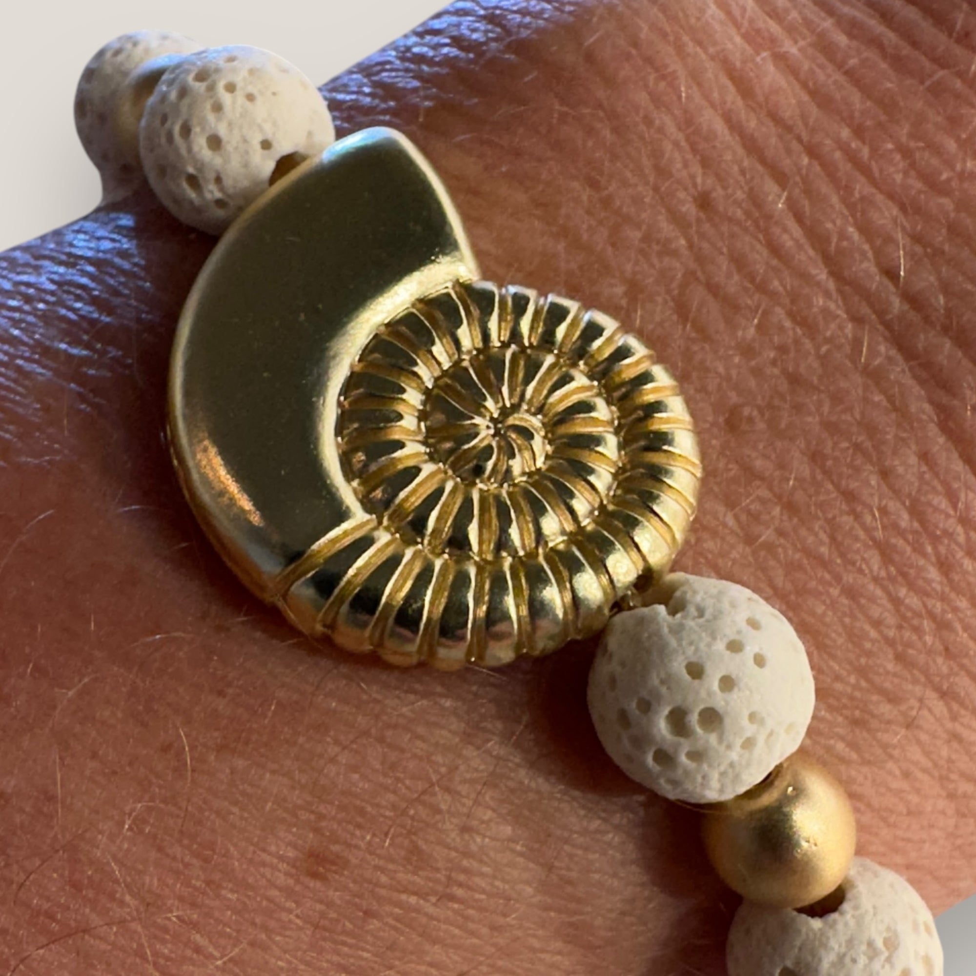 Pulsera con gran caracola y cuentas doradas con esponja coral blanca