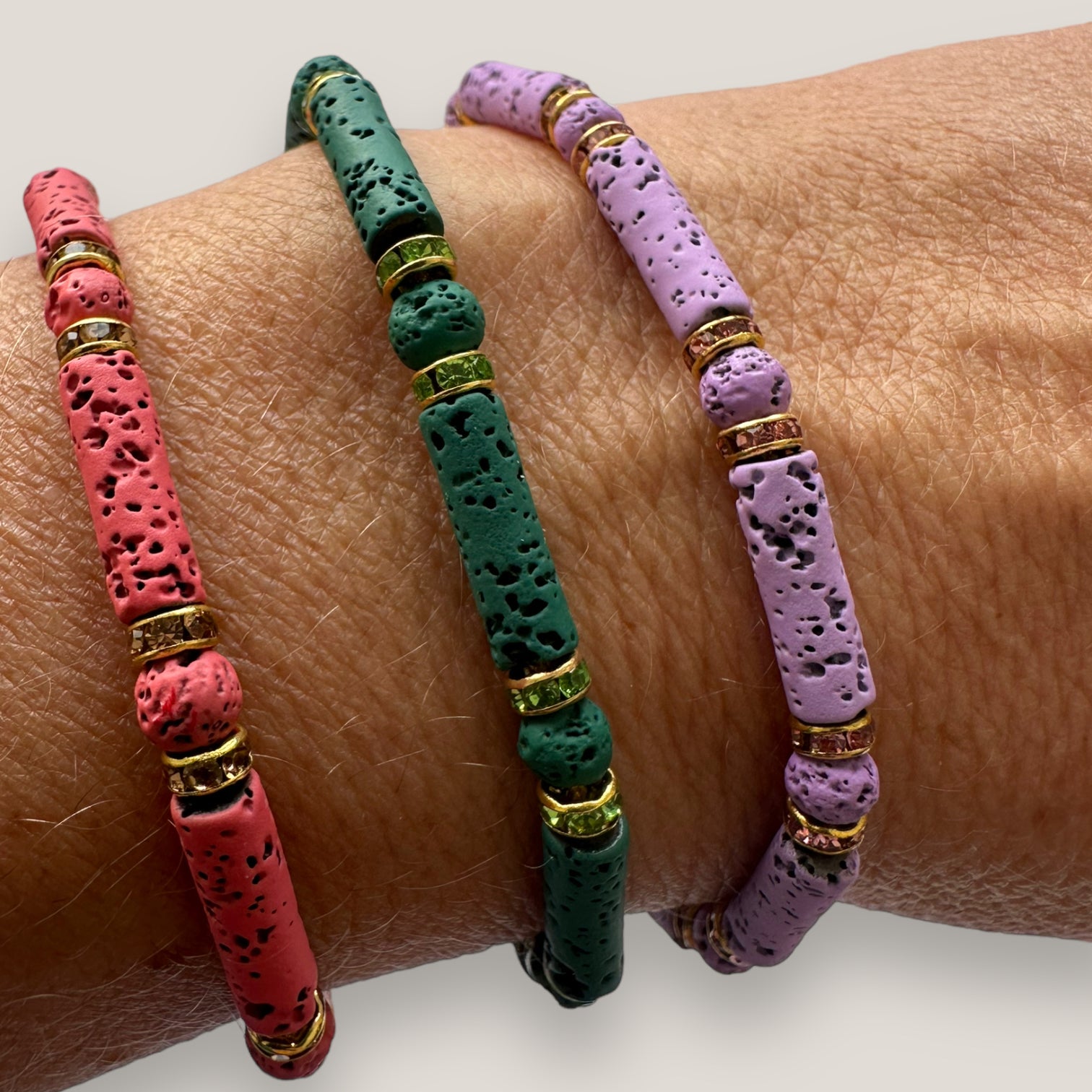 Pulsera con tubos y cuentas de lava fucsia y brillis oro con cristalitos rosas