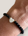 Pulsera corazón nácar con cuentas de lava negra y aros de acero oro