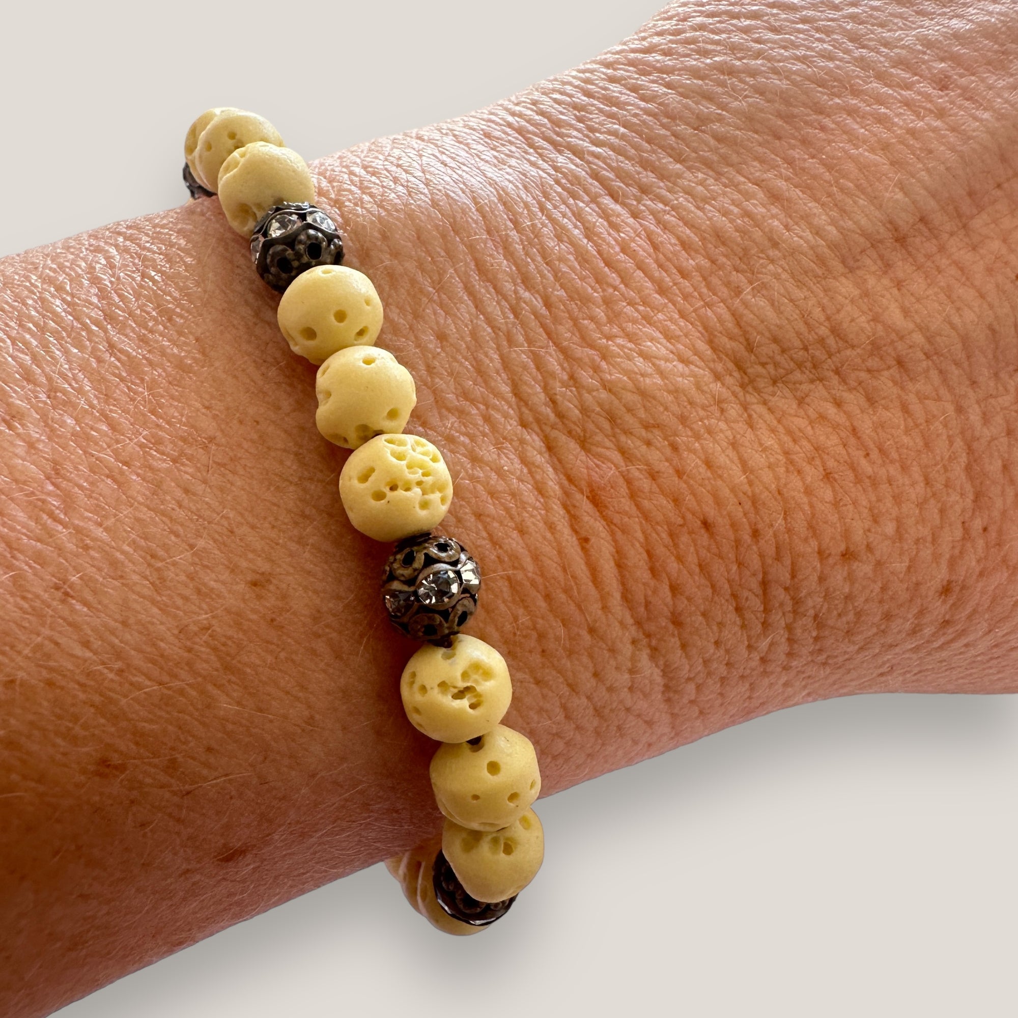 Pulsera Dafne con esponja coral amarillo claro y filigrana bronce con cristalitos