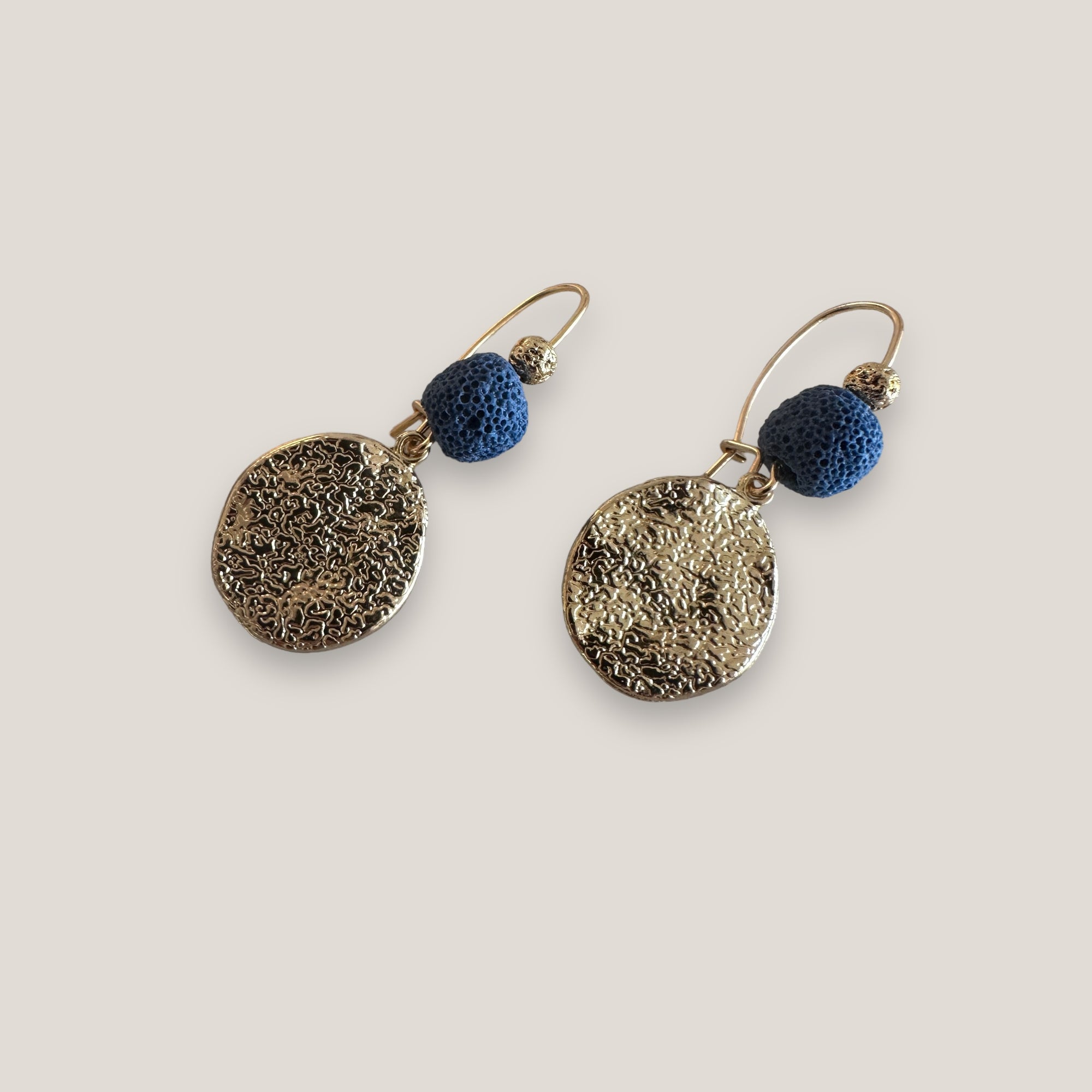 Fuerte Coral Hakenohrringe, gehämmerte goldene ovale Medaille mit marineblauer Korallenschwammkugel und vergoldeter Lava