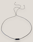 Collar minimal con tubo de lava negra y cuentas plata con brillis blancos