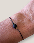 Pulsera minimal con bola de lava negra y cuentas doradas con brilli negros