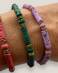 Pulsera con tubos y cuentas de lava malva y brillis oro con cristalitos rosas