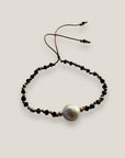 Pulsera Eloise negro con perla natural blanca, cristales facetados negros y sepatradores oro rosa