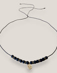 Collar midi con moneda tribal dorada, cuentas de lava negra y separadores oro y brillis negros
