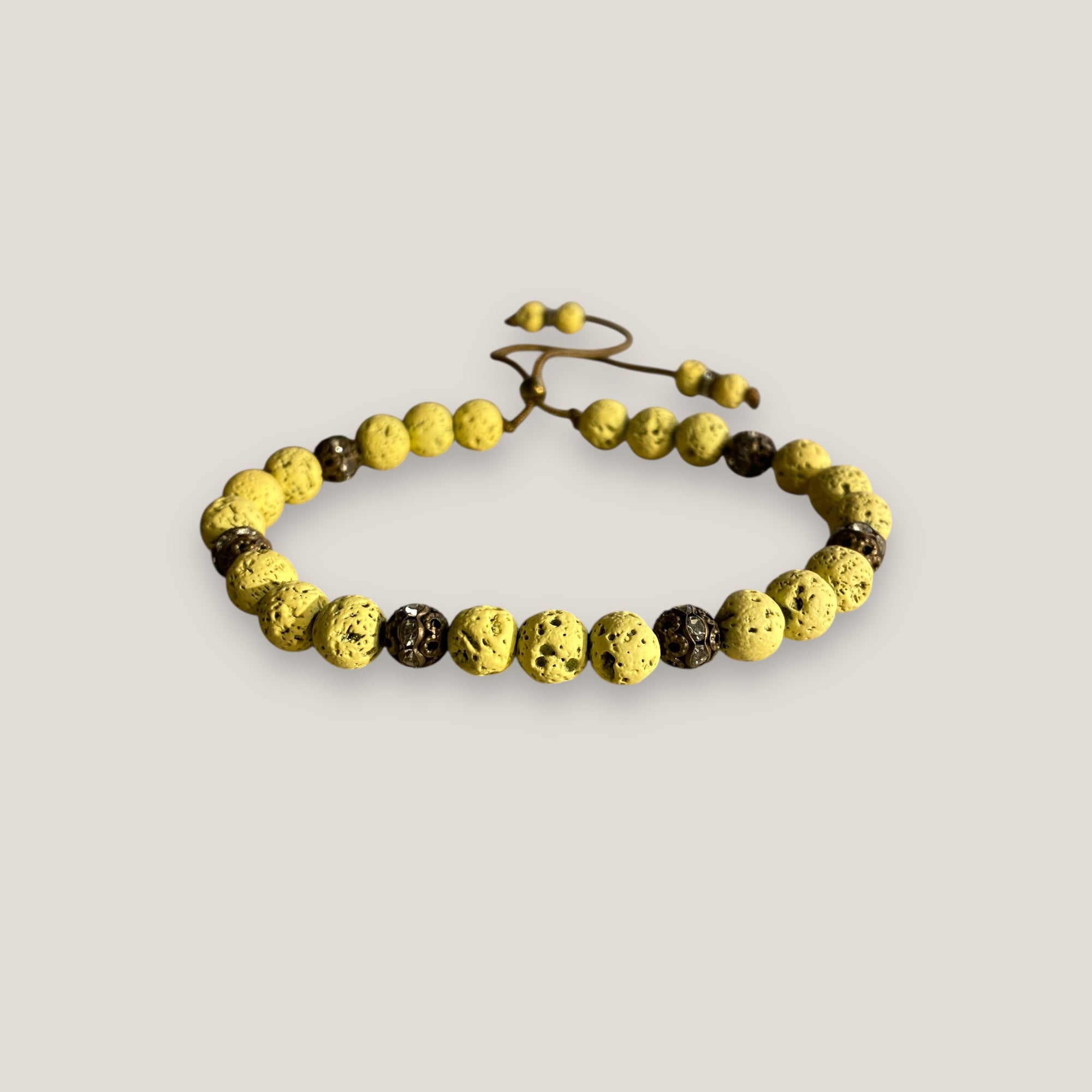 Pulsera Dafne con lava amarillo claro y filigrana bronce con cristalitos