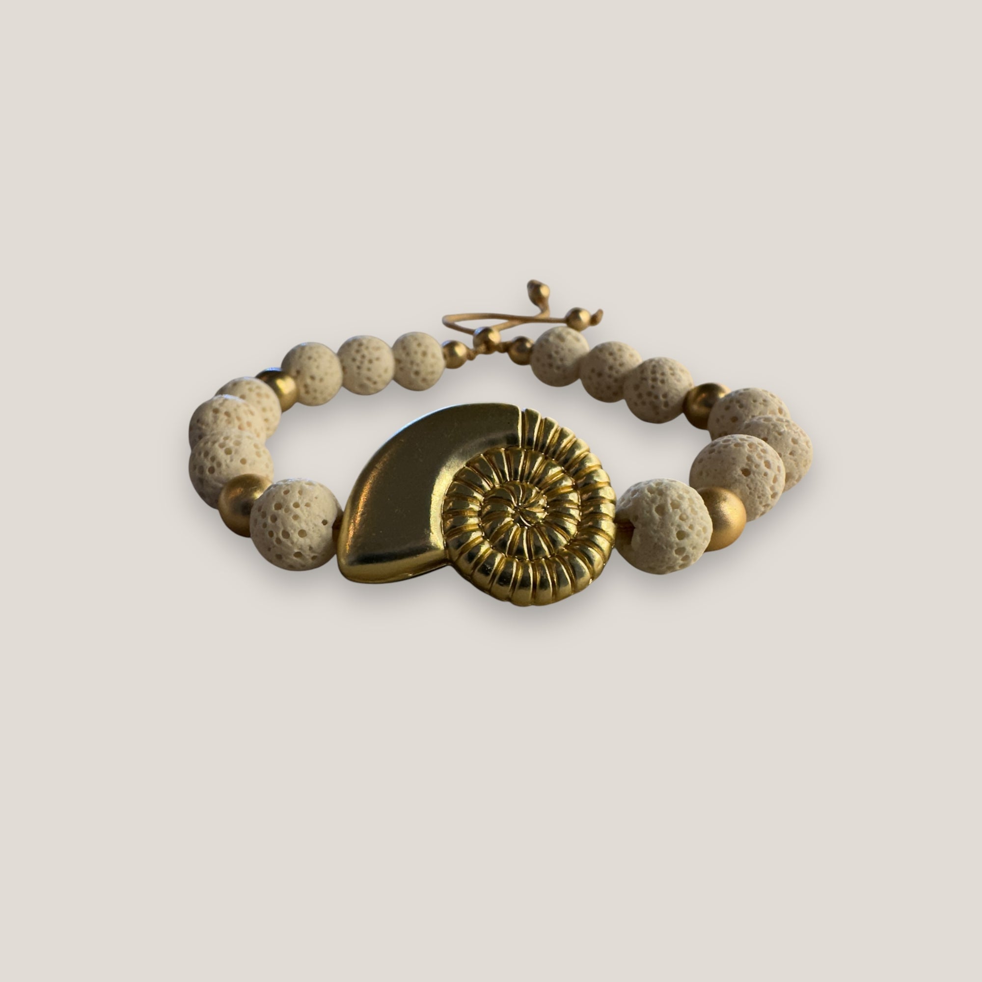Pulsera con gran caracola y cuentas doradas con esponja coral blanca