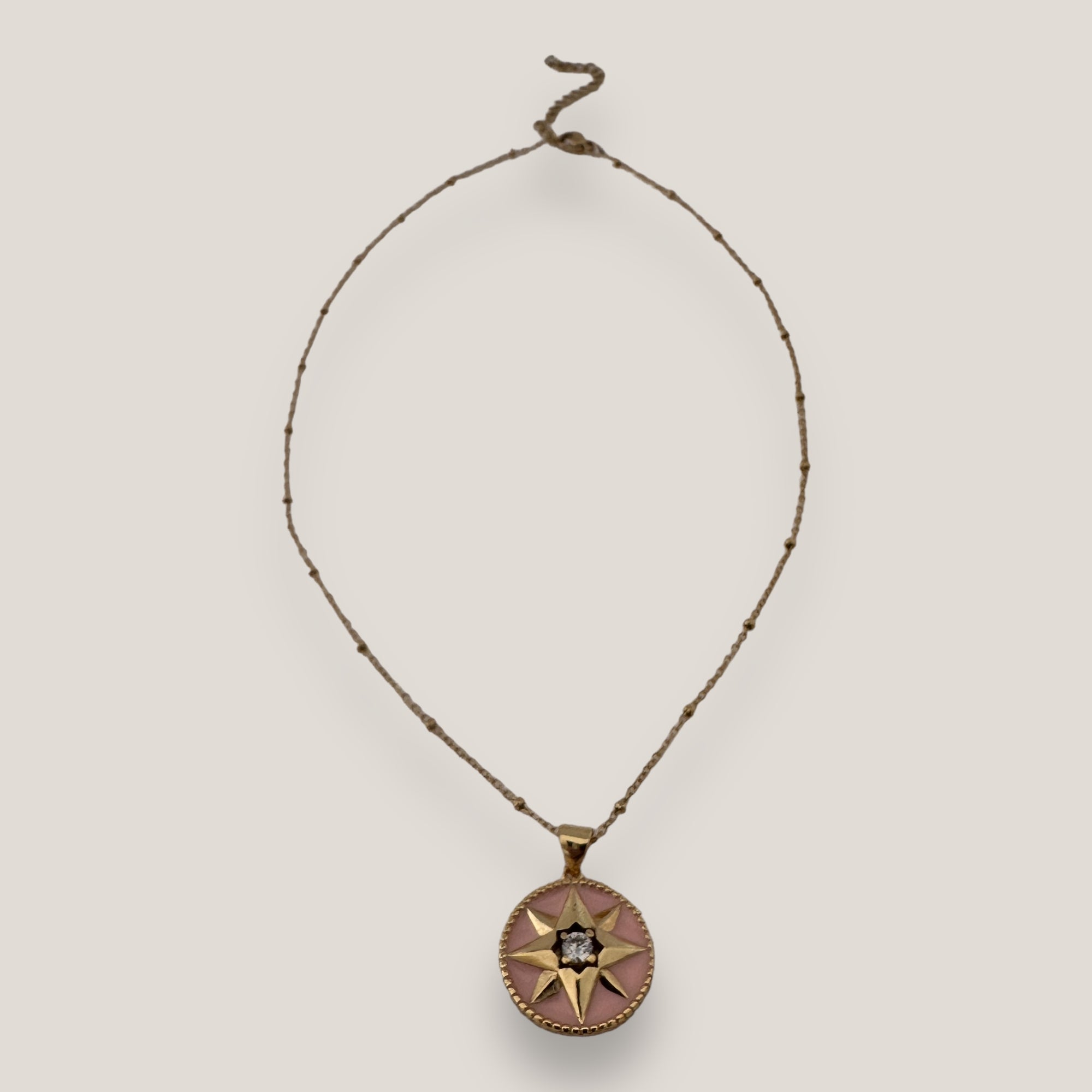 Collar Rosa de los vientos con esmalte en rosa y circonita blanca en el centro, cadena con bolitas acero oro