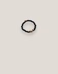 Anillo Divino negro con perlita natural blanca y separadores oro rosa