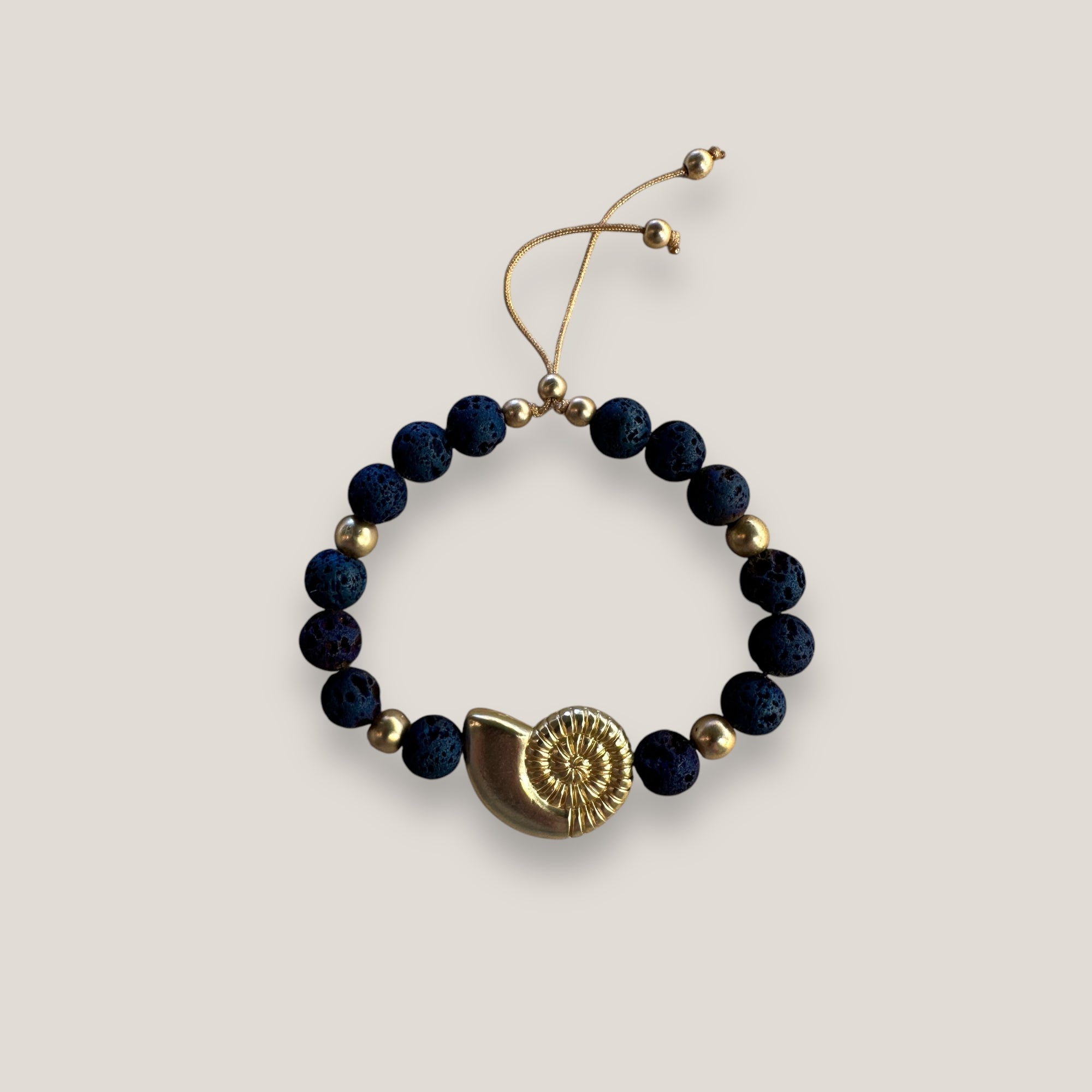 Armband mit großer Muschel und goldenen Perlen mit indigoblauer Lava