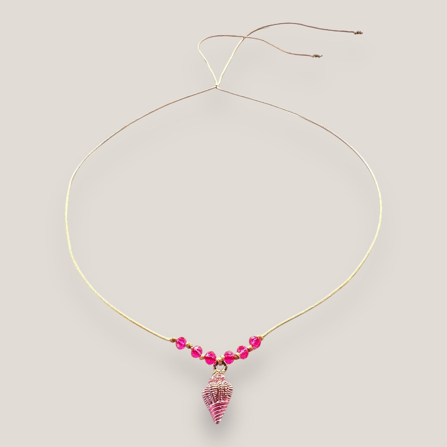 Collar midi con caracola dorada con esmalte fucsia y cristales facetados fucsia