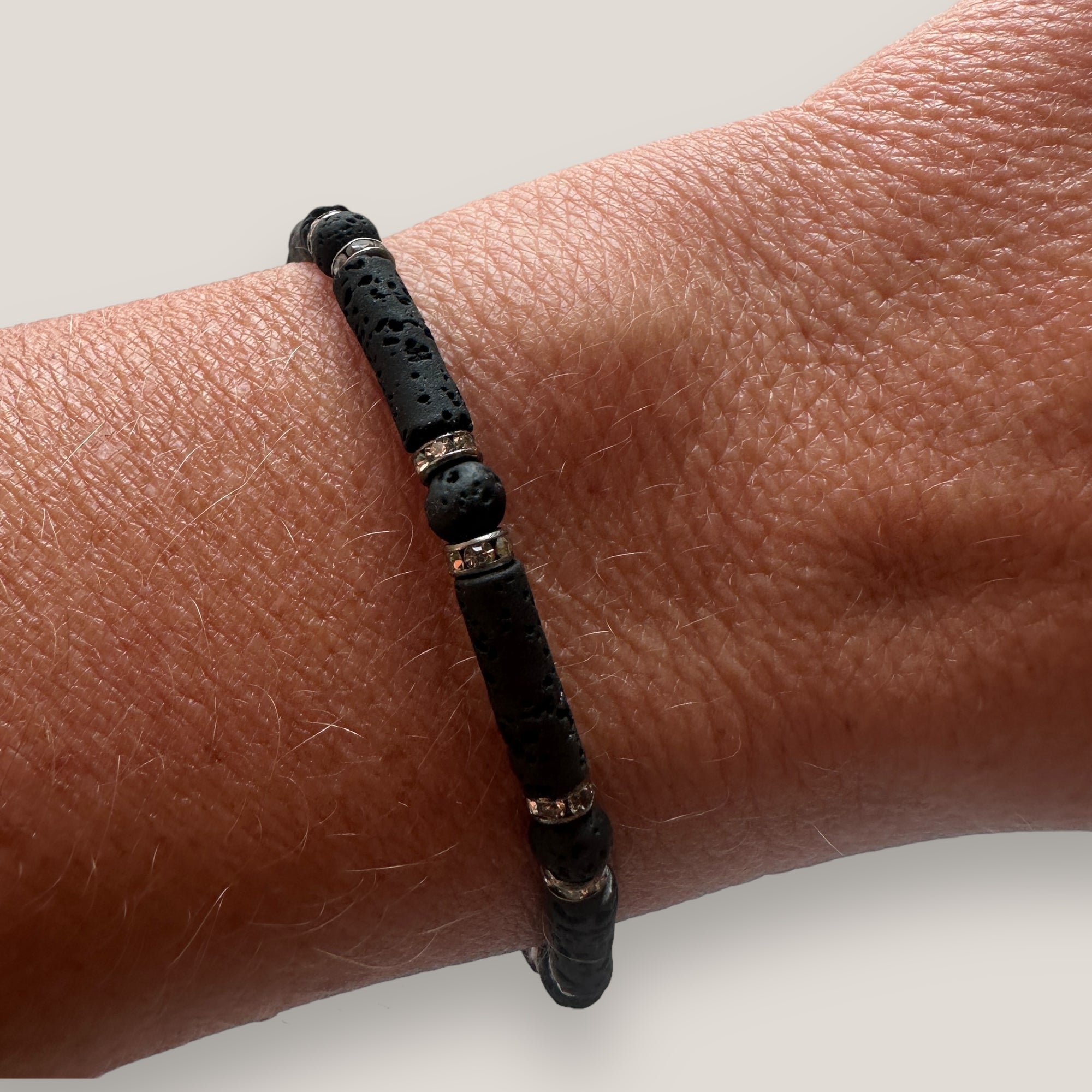 Pulsera con tubos y cuentas de lava negra y brillis gunmetal con cristalitos blancos