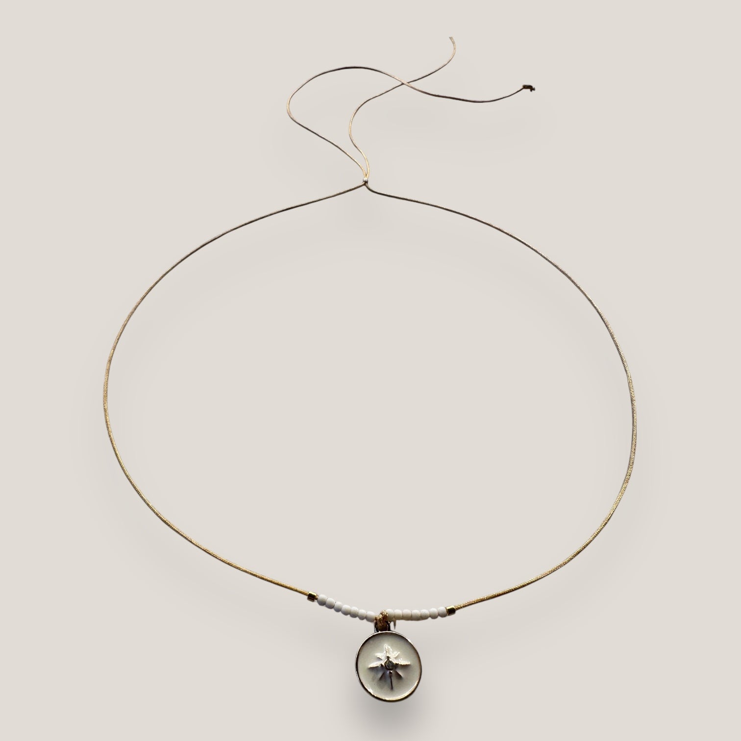 Collar midi con medalla dorada esmaltada en blanco con estrella dorada con circonita