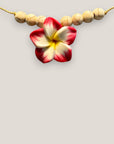 Collar midi flor Plumeria fucsia amarilla howlitas naturales