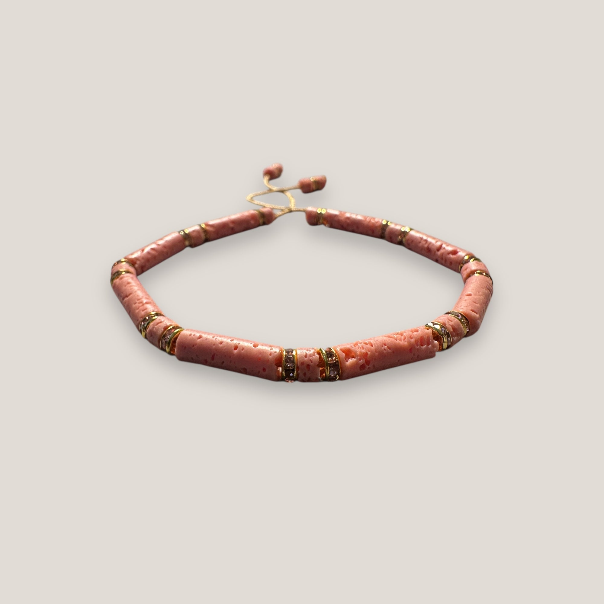 Pulsera con tubos y discos de esponja coral rosa y brillis oro con cristales rosas