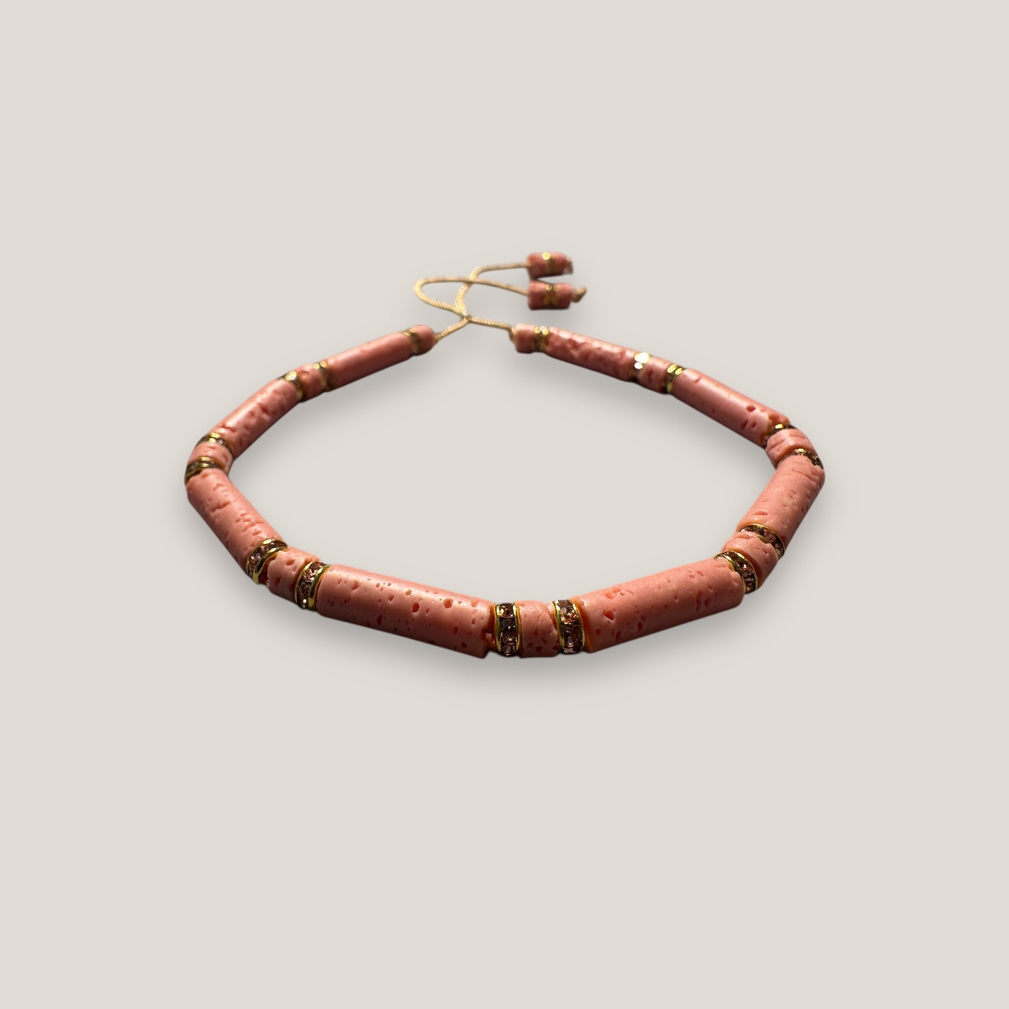 Pulsera con tubos y discos de esponja coral rosa y brillis oro con cristales rosas