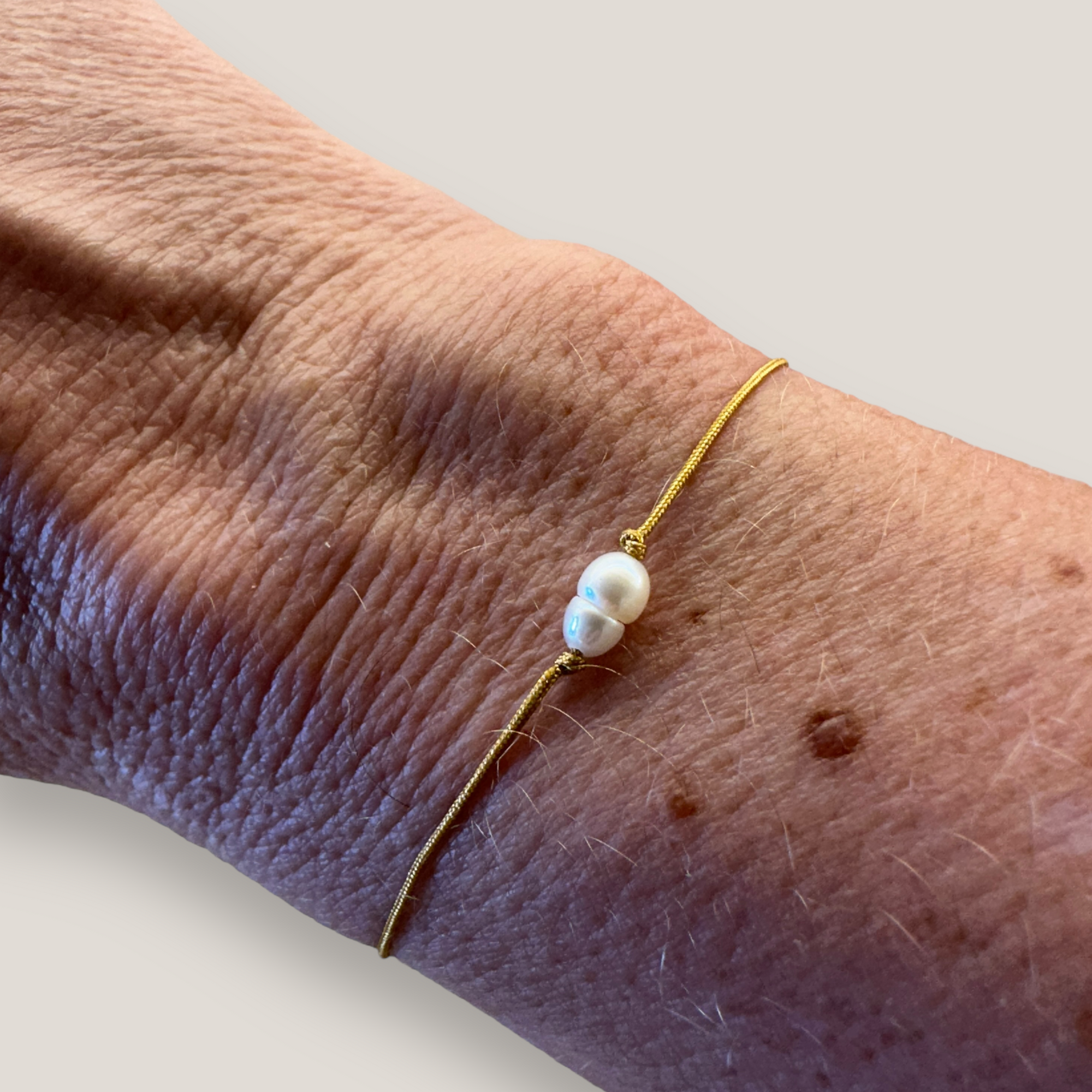 Pulsera minimal con perla natural alargada blanca irregular