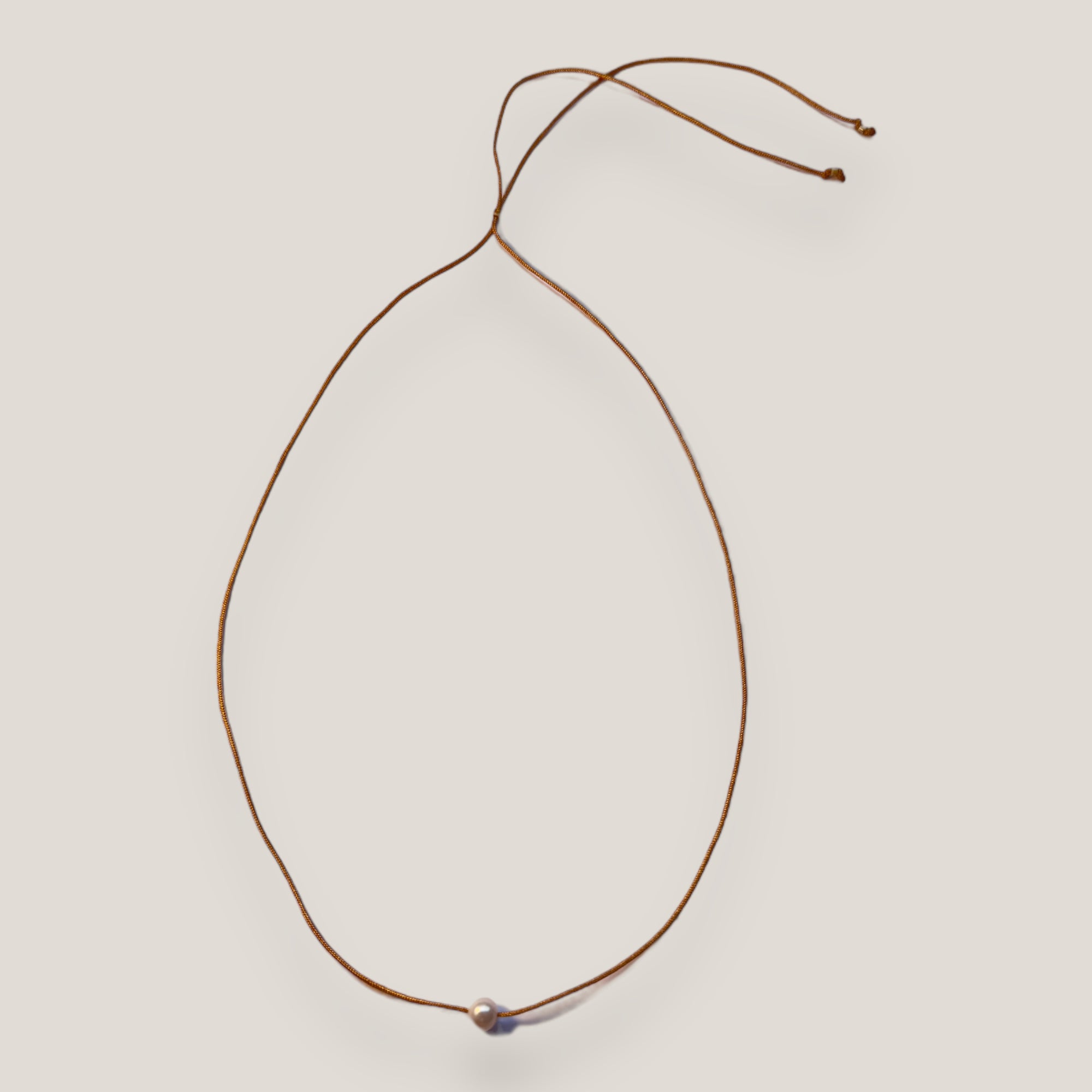 Collar minimal con perla natural blanca y cordón de nailon