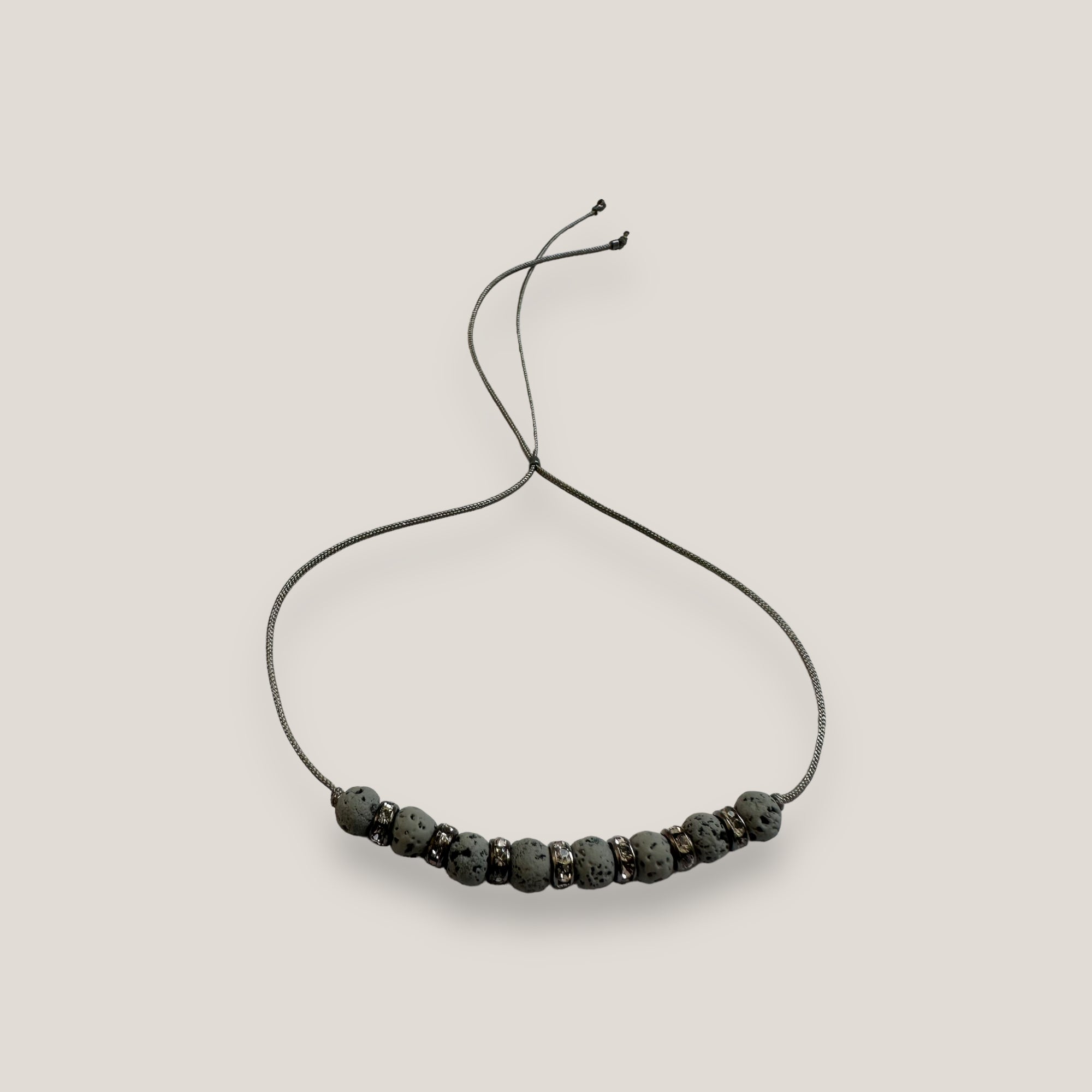 Pulsera minimal con ocho bolitas de lava gris claro y brillis blancos