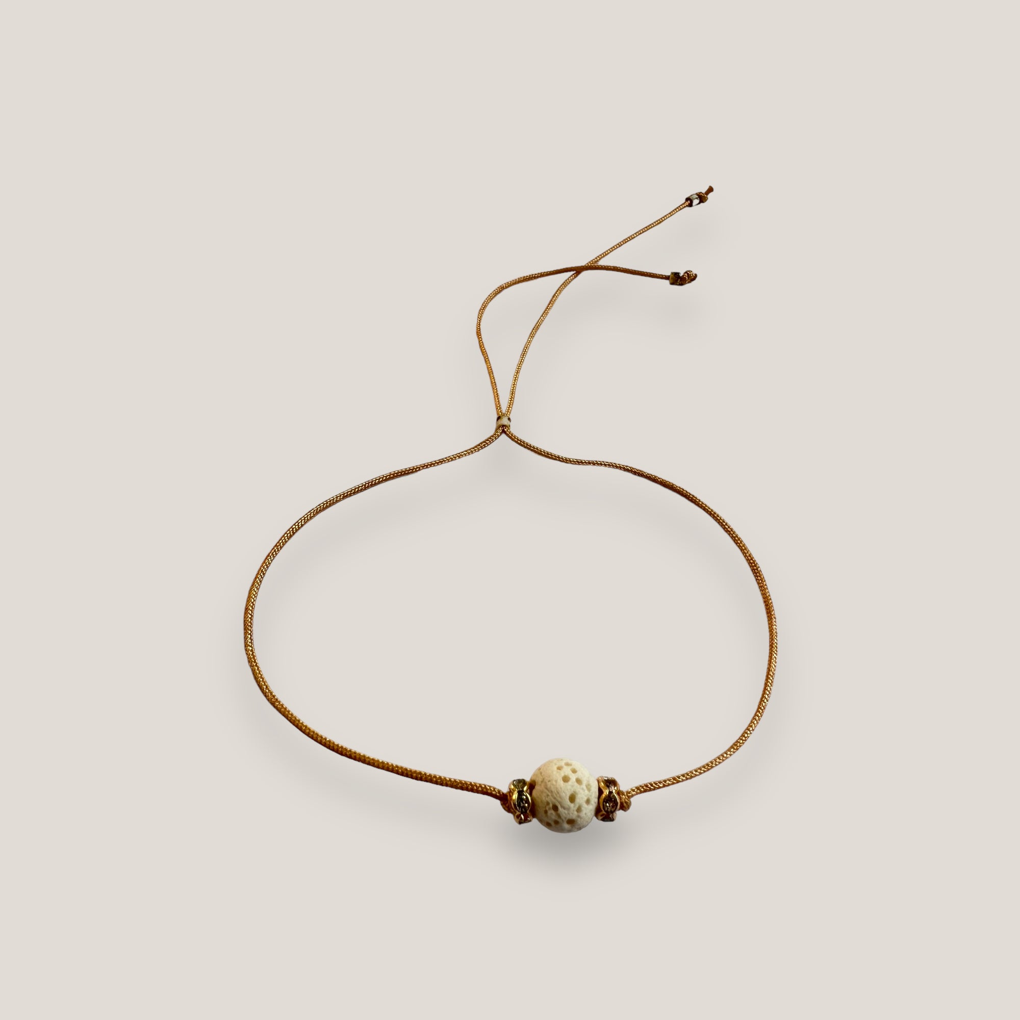 Pulsera minimal con bola esponja coral blanco y cuentas doradas con brillis lux blancos